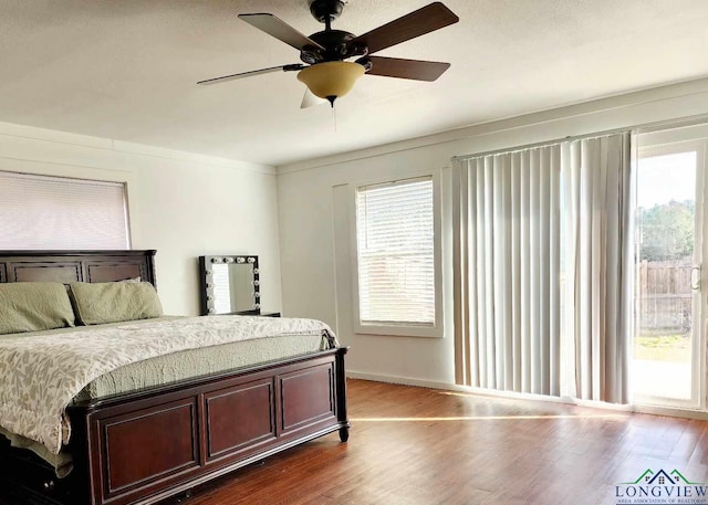 bedroom featuring multiple windows, wood-type flooring, and ceiling fan