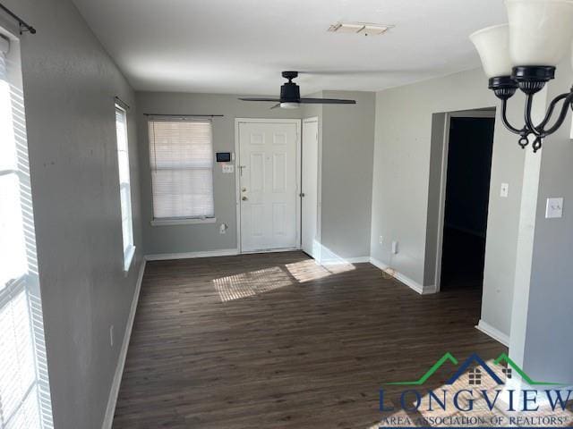 foyer entrance featuring dark hardwood / wood-style flooring and ceiling fan with notable chandelier