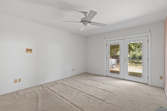 carpeted spare room featuring french doors and ceiling fan