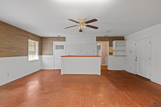 unfurnished living room with ceiling fan and sink