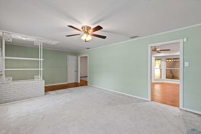 carpeted empty room with ceiling fan and ornamental molding