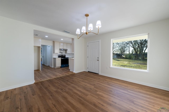 unfurnished living room featuring a notable chandelier and dark wood-type flooring