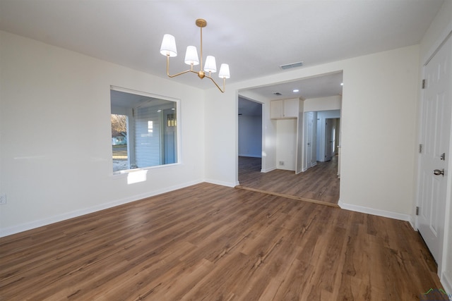 unfurnished dining area with a notable chandelier and dark hardwood / wood-style flooring