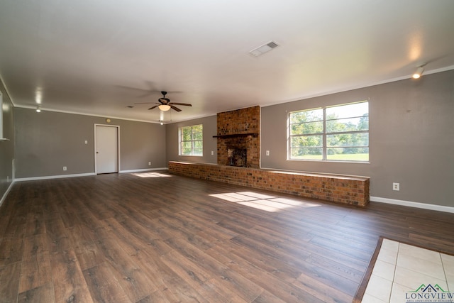 unfurnished living room with hardwood / wood-style flooring, ceiling fan, a healthy amount of sunlight, and a fireplace