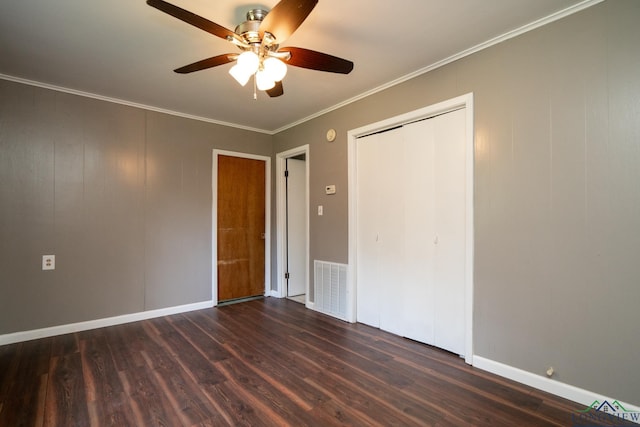 unfurnished bedroom featuring a closet, dark hardwood / wood-style floors, ceiling fan, and ornamental molding