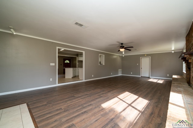 unfurnished living room with ceiling fan, ornamental molding, dark hardwood / wood-style floors, and a brick fireplace