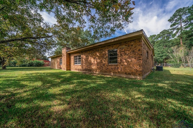 view of home's exterior with a lawn and central air condition unit