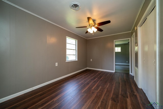 spare room with dark hardwood / wood-style floors, a wealth of natural light, and crown molding