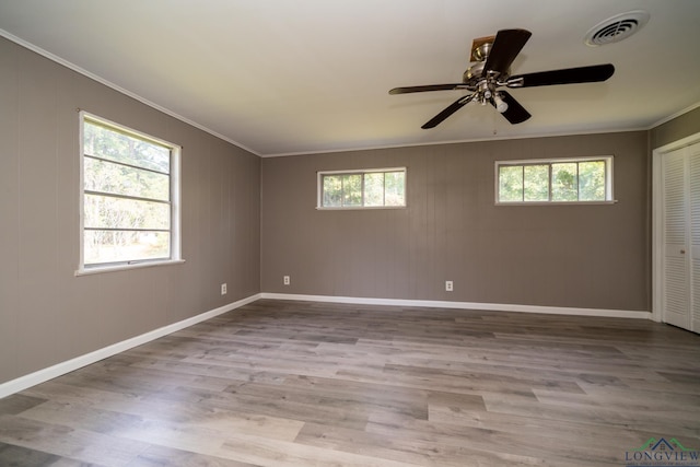 empty room featuring crown molding, plenty of natural light, and ceiling fan