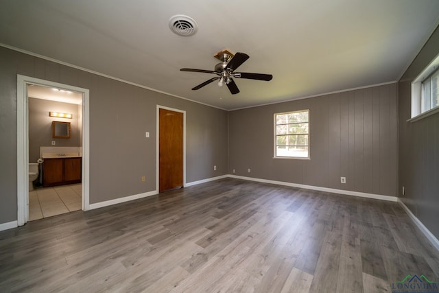 unfurnished bedroom with ornamental molding, ensuite bathroom, ceiling fan, and light hardwood / wood-style floors