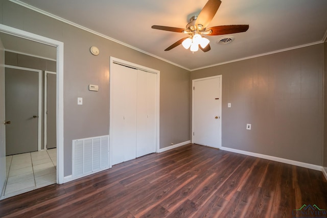 unfurnished bedroom with ceiling fan, ornamental molding, and dark wood-type flooring