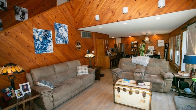 living room featuring visible vents, recessed lighting, wood walls, and light wood-type flooring