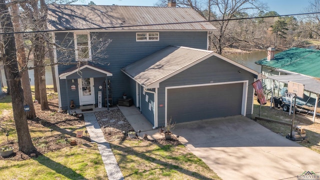 view of front of house with concrete driveway, metal roof, and an attached garage