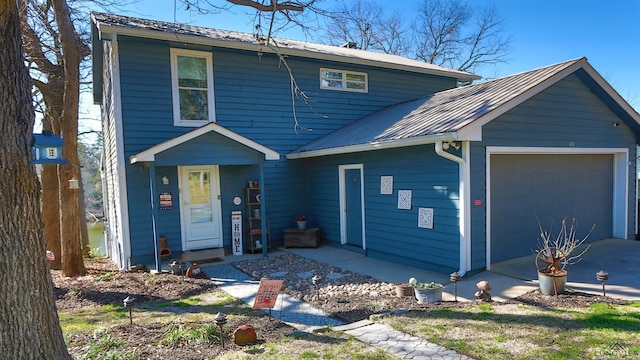 view of front facade with metal roof, a garage, and concrete driveway