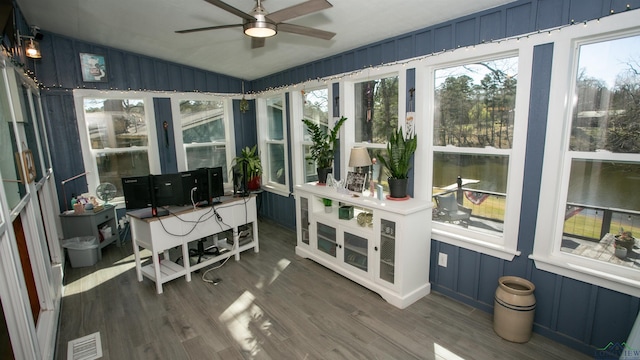 sunroom / solarium with vaulted ceiling, visible vents, wood finished floors, and a ceiling fan