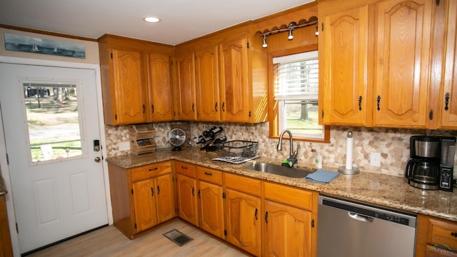 kitchen with dishwasher, a sink, light wood finished floors, and brown cabinets