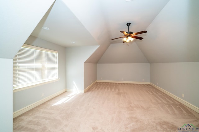 additional living space featuring light carpet, ceiling fan, and vaulted ceiling