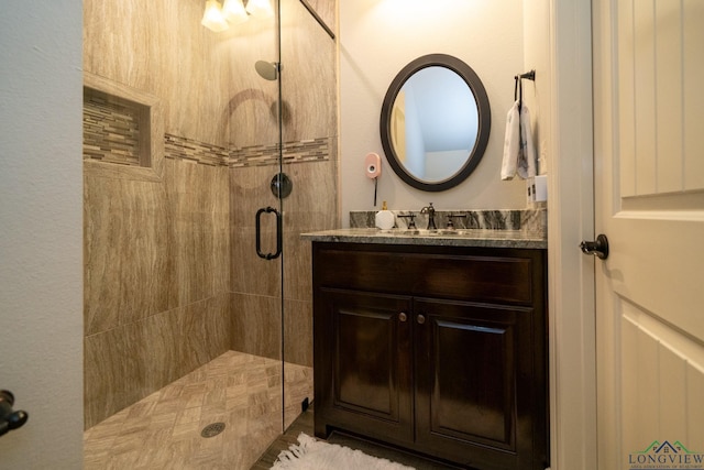 bathroom with a shower with door and vanity