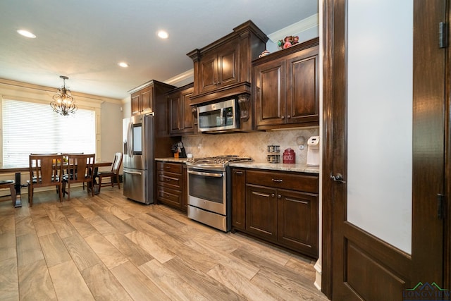 kitchen with dark brown cabinetry, crown molding, stainless steel appliances, and decorative light fixtures