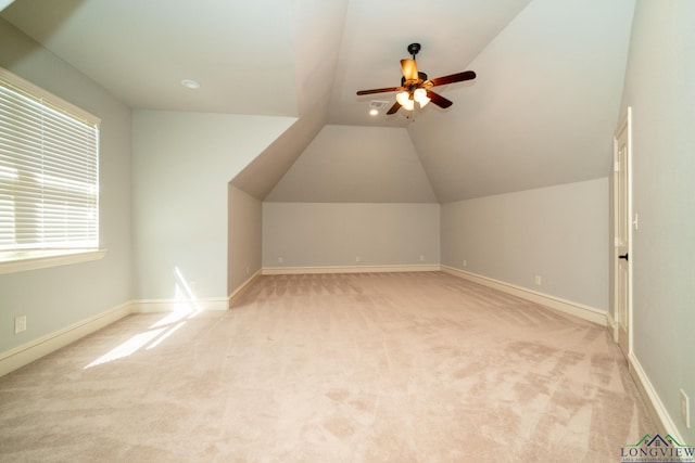 additional living space with light colored carpet, vaulted ceiling, and ceiling fan