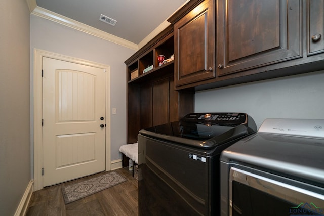 washroom with cabinets, washing machine and dryer, dark hardwood / wood-style floors, and ornamental molding