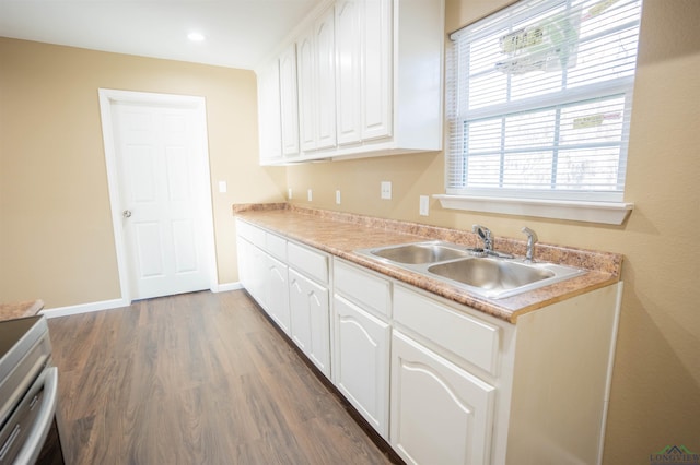 kitchen with stainless steel range with electric stovetop, sink, dark hardwood / wood-style floors, and white cabinets