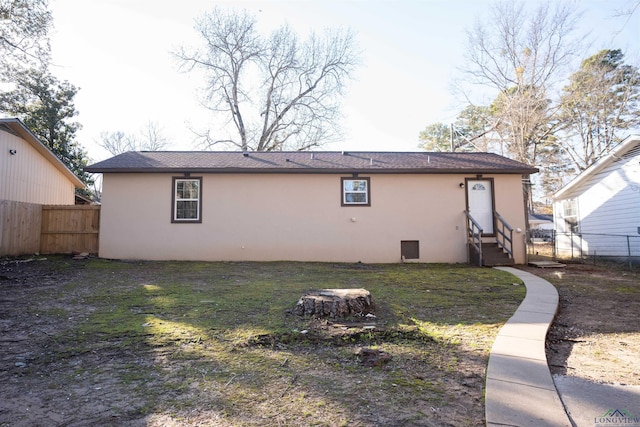 rear view of property featuring a lawn