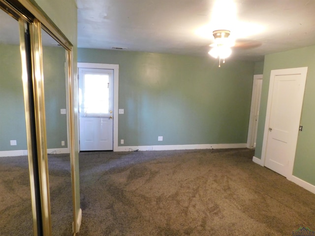 unfurnished room with dark carpet