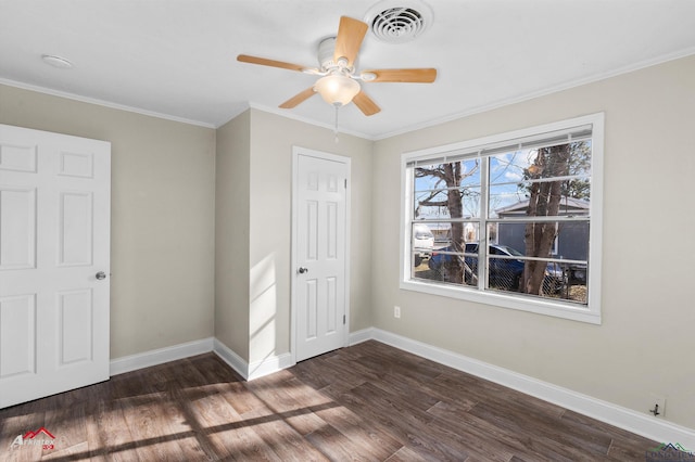 unfurnished bedroom with dark hardwood / wood-style flooring, a closet, ceiling fan, and crown molding