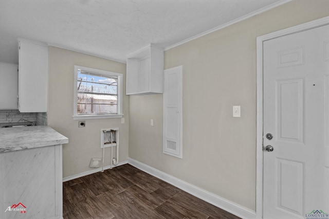 washroom with electric dryer hookup, crown molding, and dark wood-type flooring