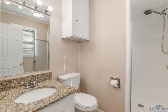 bathroom featuring toilet, a tile shower, ornamental molding, and vanity