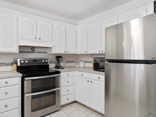 kitchen with light tile patterned floors, backsplash, stainless steel appliances, and white cabinetry