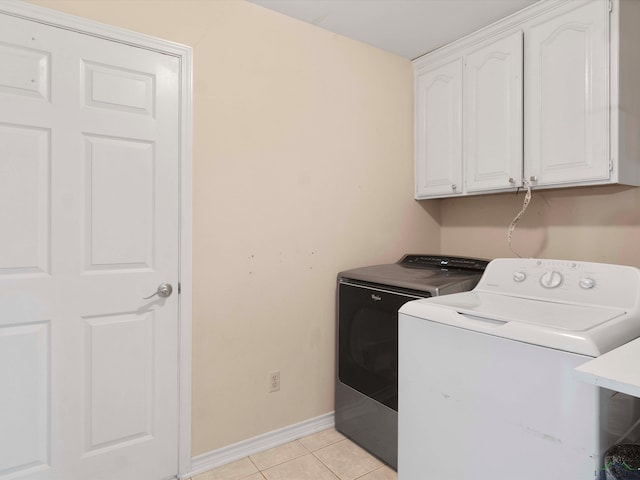 clothes washing area featuring cabinets, light tile patterned floors, and independent washer and dryer