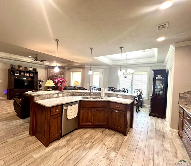 kitchen with sink, a raised ceiling, stainless steel dishwasher, pendant lighting, and ornamental molding