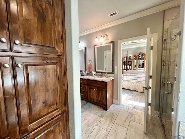 bathroom with vanity, an enclosed shower, and ornamental molding