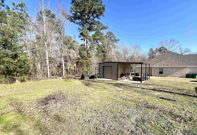 view of yard featuring an outbuilding, a carport, and a garage