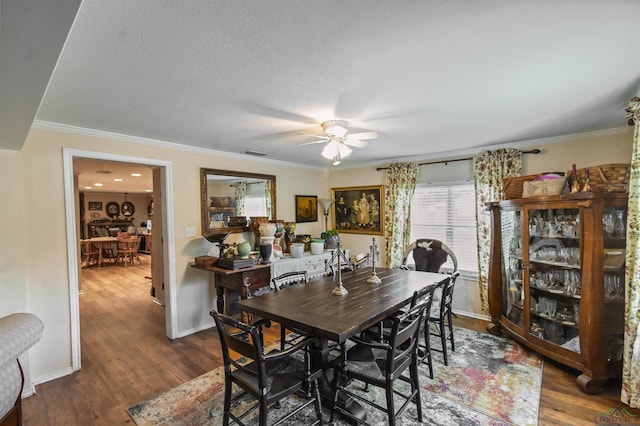 dining room featuring a textured ceiling, ceiling fan, dark hardwood / wood-style floors, and ornamental molding