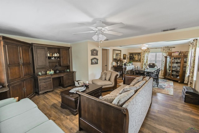 living room featuring ceiling fan, ornamental molding, and dark wood-type flooring