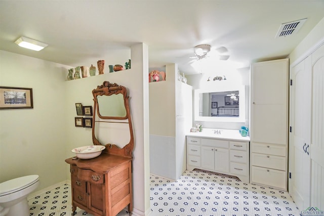 bathroom with vanity, ceiling fan, and toilet