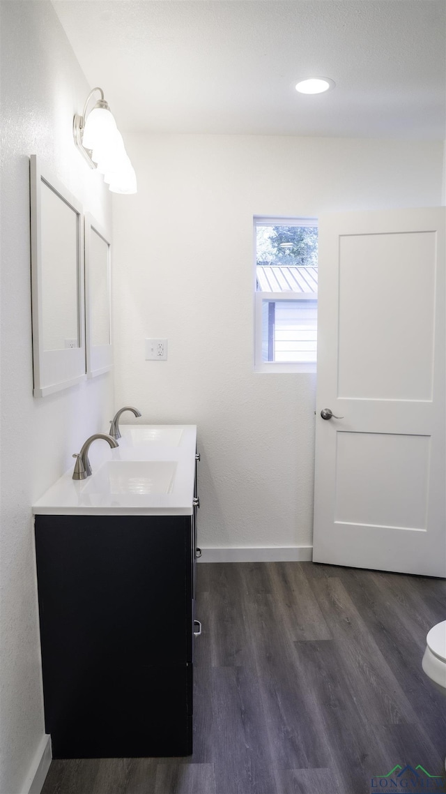 bathroom with vanity, hardwood / wood-style flooring, and toilet