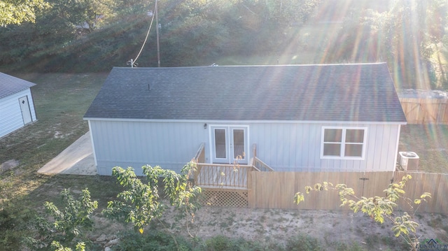 back of property with french doors and central AC unit