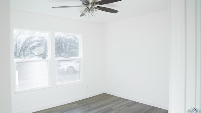 spare room with dark hardwood / wood-style flooring and ceiling fan