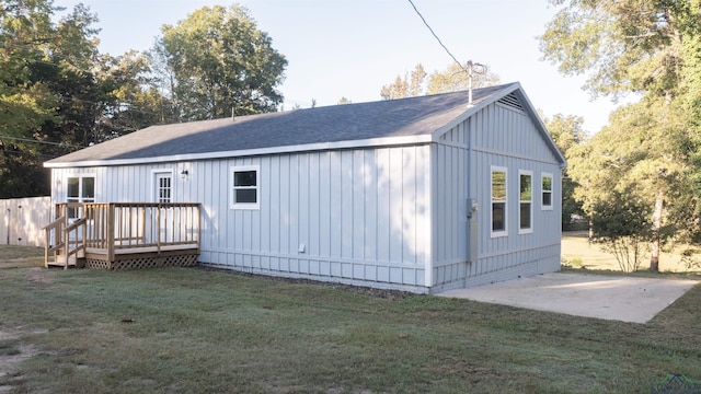 back of house featuring a yard, a patio, and a wooden deck