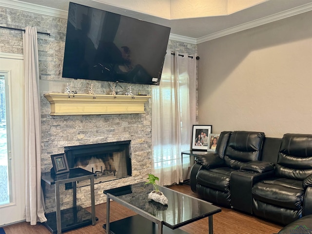 living room featuring hardwood / wood-style flooring, a fireplace, and crown molding