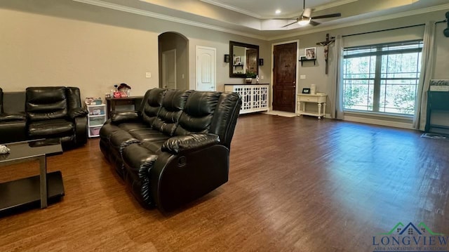 living room featuring ceiling fan, dark hardwood / wood-style floors, a raised ceiling, and ornamental molding