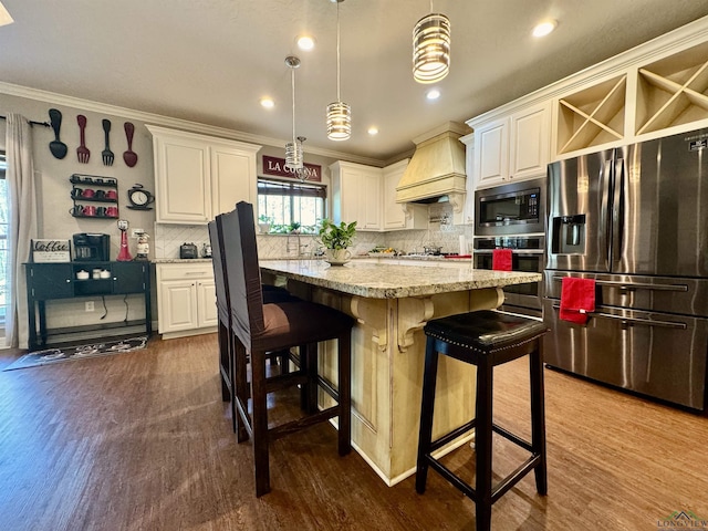 kitchen with custom exhaust hood, stainless steel appliances, pendant lighting, a center island, and white cabinetry