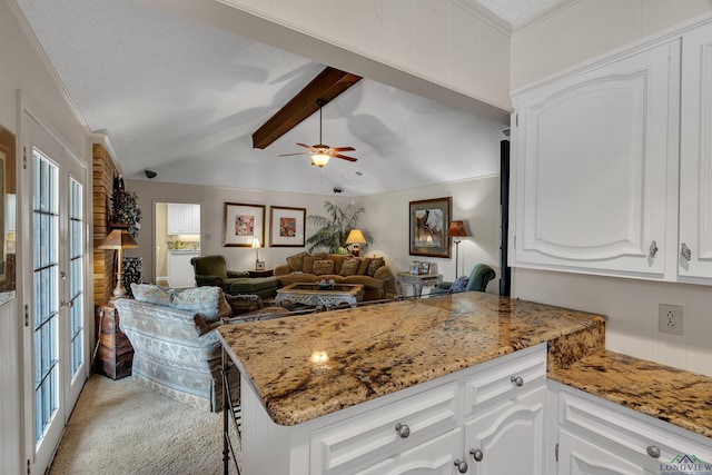 1303 Le Duke Blvd, Longview, TX 75601 - kitchen with a peninsula, white cabinetry, light carpet, open floor plan, and ornamental molding
