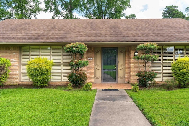 1303 Le Duke Blvd, Longview, TX 75601 - view of front of home with brick siding, a shingled roof, and a front yard