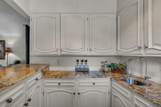 1303 Le Duke Blvd, Longview, TX 75601 - kitchen featuring white cabinets, light stone counters, and a textured ceiling