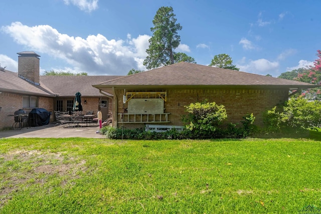 1303 Le Duke Blvd, Longview, TX 75601 - back of property with brick siding, a patio area, a lawn, and roof with shingles
